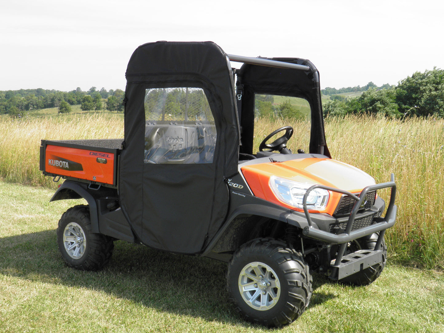 Utility vehicle with a black enclosure in a grassy field